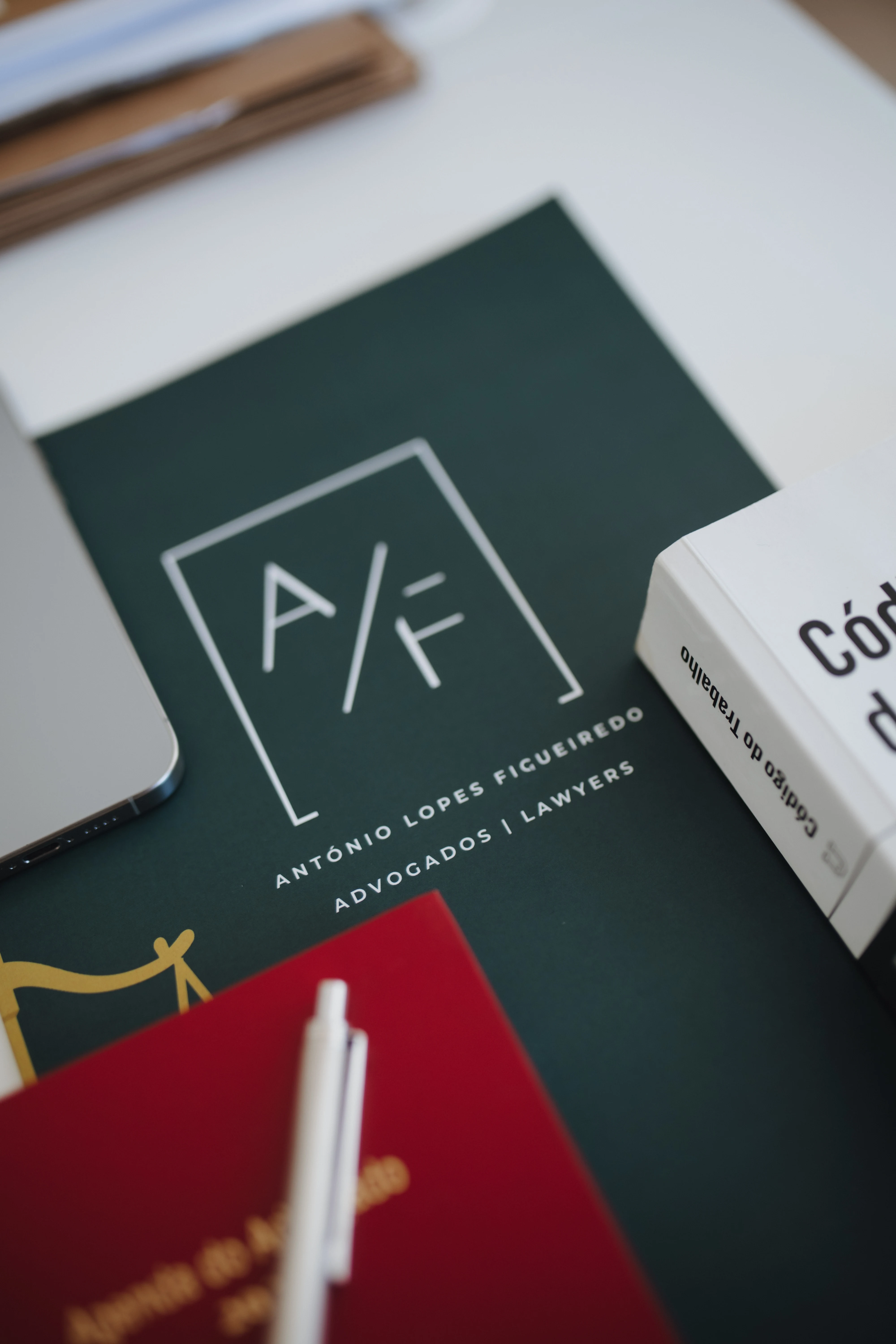Identidade visual da ALF Advogados numa secretária de trabalho