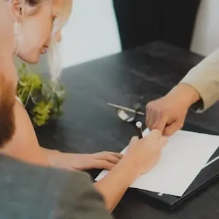 Advogado e clientes a conversar à mesma mesa com documentos